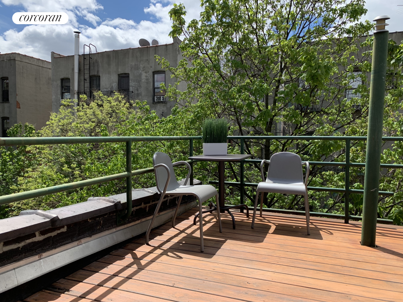 a view of a balcony with wooden floor and outdoor seating