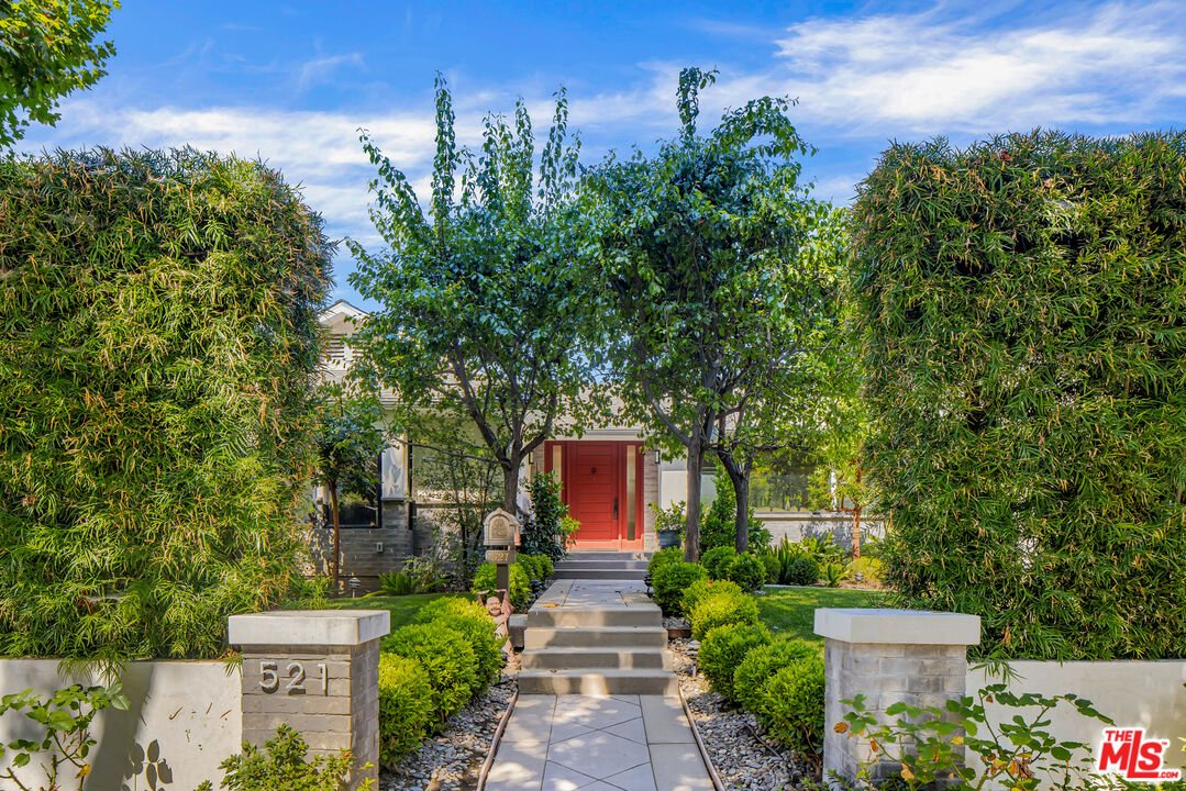 a front view of a house with a yard and fountain in middle