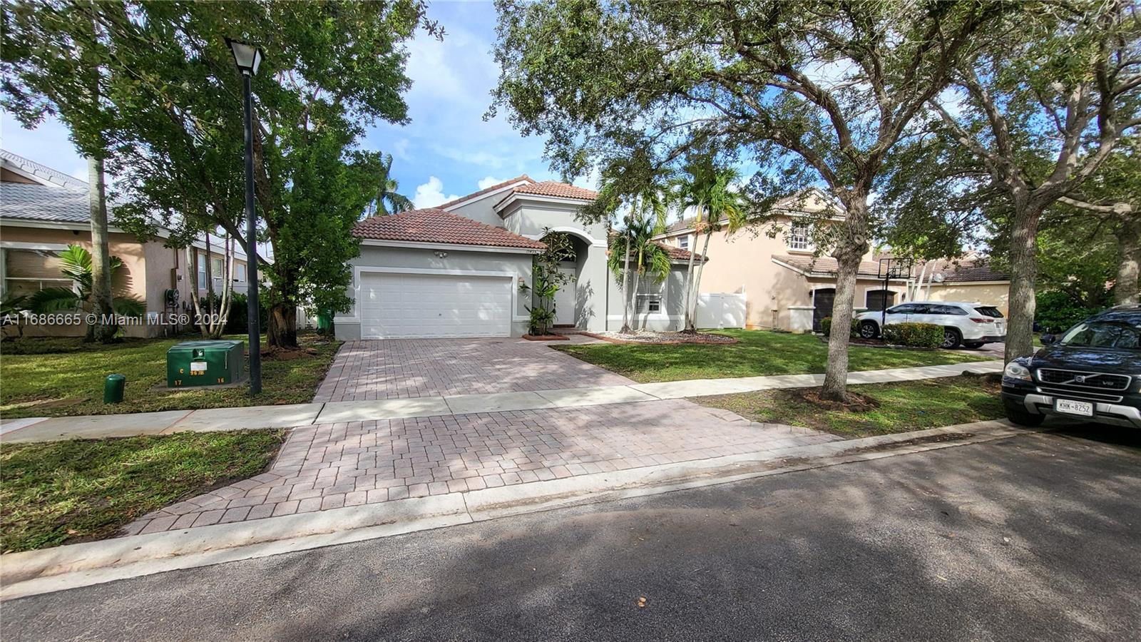 a view of a house with a yard and large trees