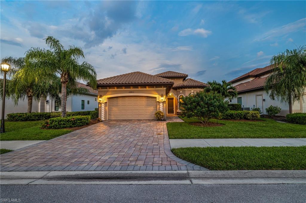 Mediterranean / spanish-style house with a garage and a front lawn