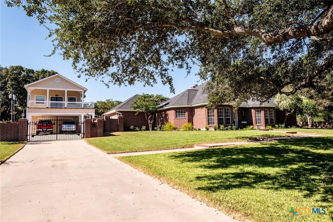 a front view of a house with a yard and trees