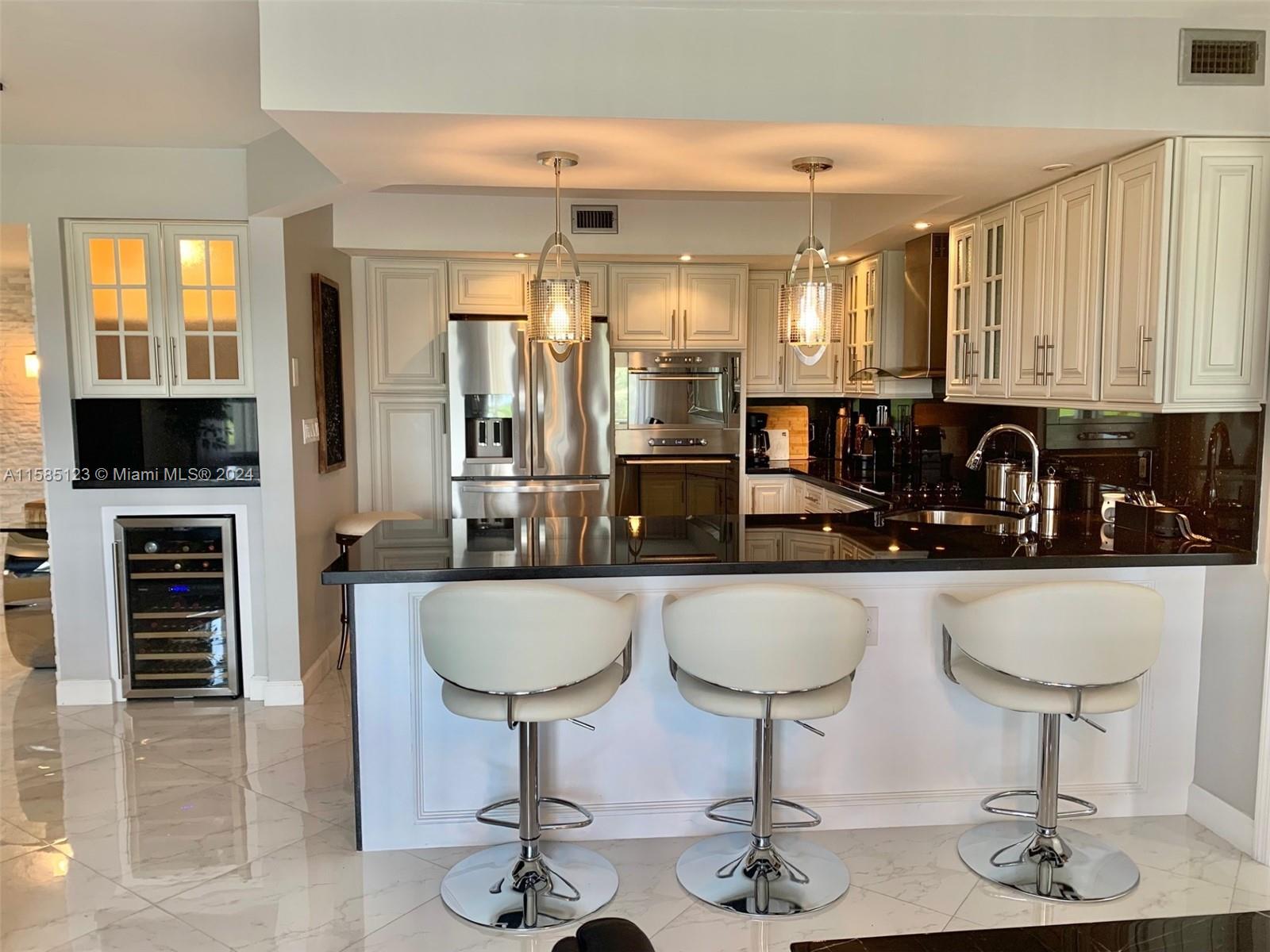 a kitchen with granite countertop a counter space a sink stainless steel appliances and cabinets