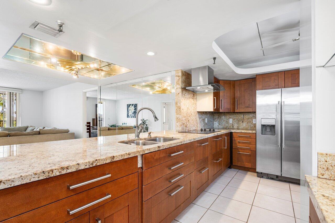 a large kitchen with stainless steel appliances kitchen island granite countertop a sink and cabinets