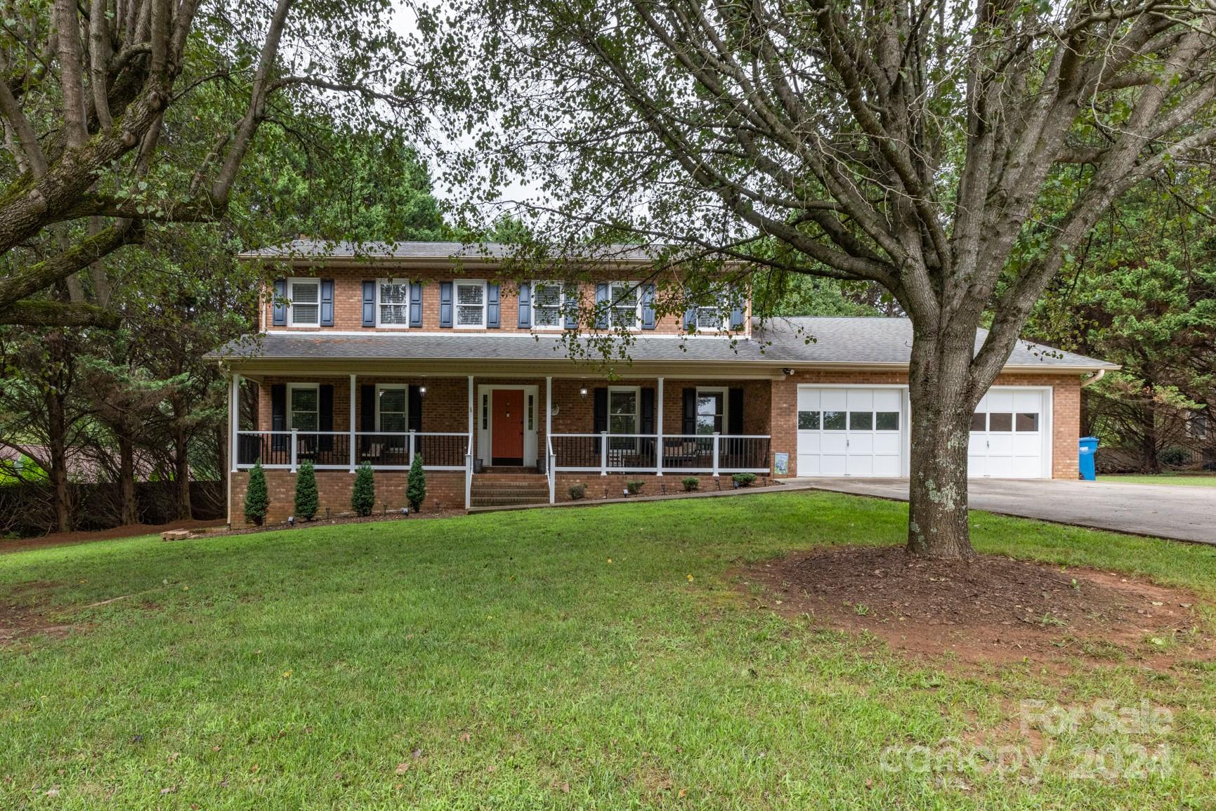 a view of a brick house with a large windows and large trees