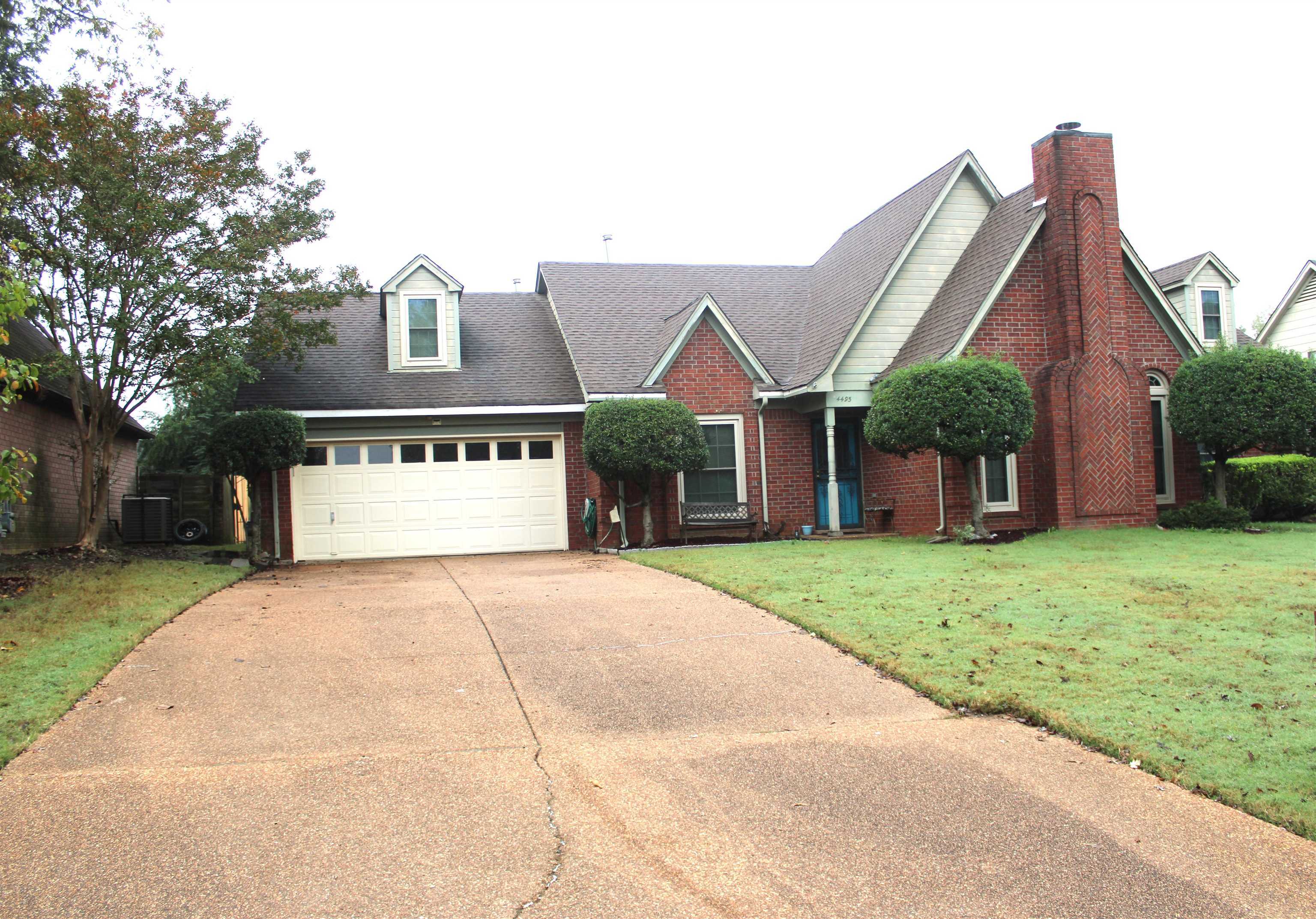 a view of a house with a yard and tree