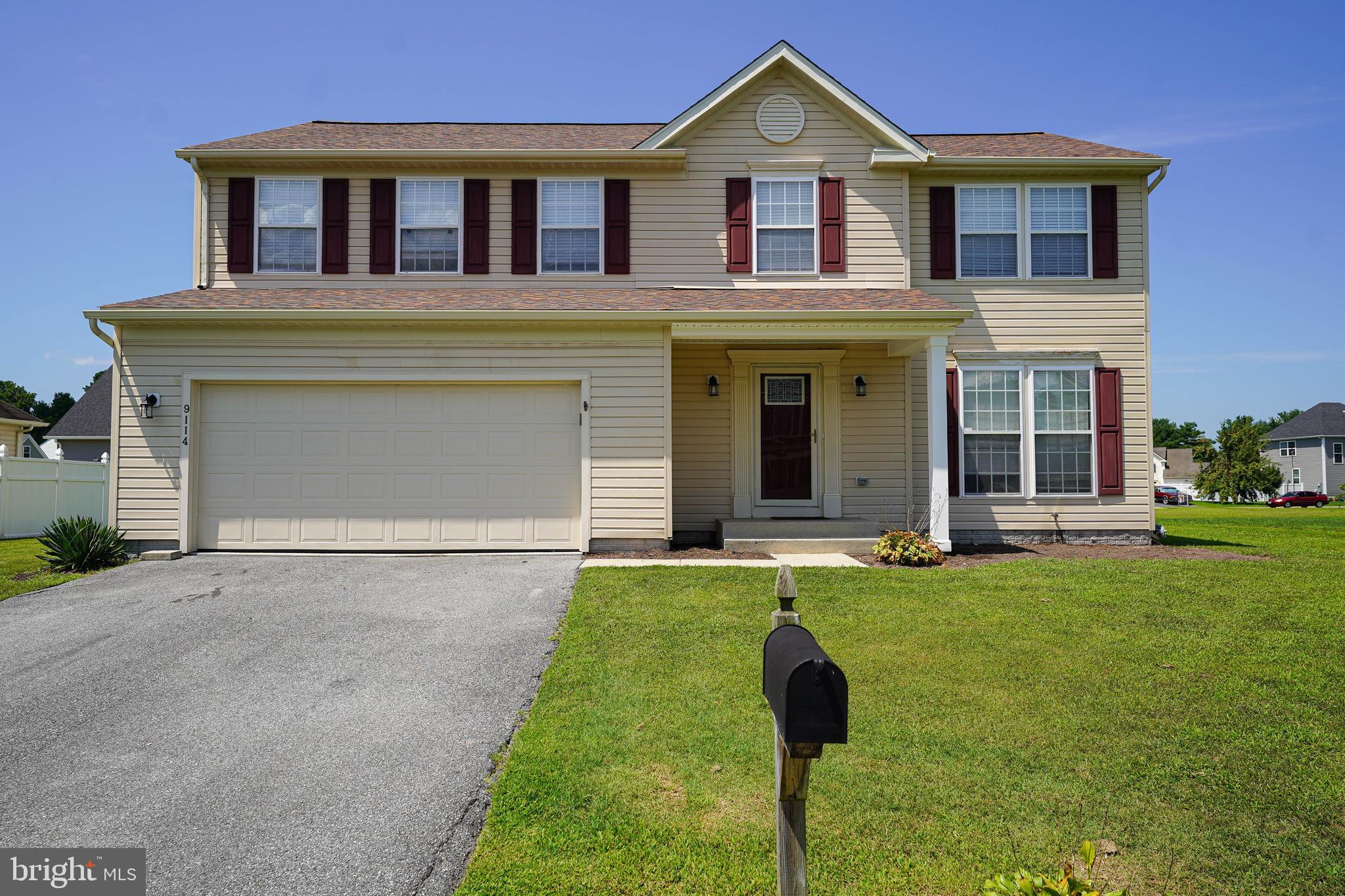 a front view of a house with a garden and yard