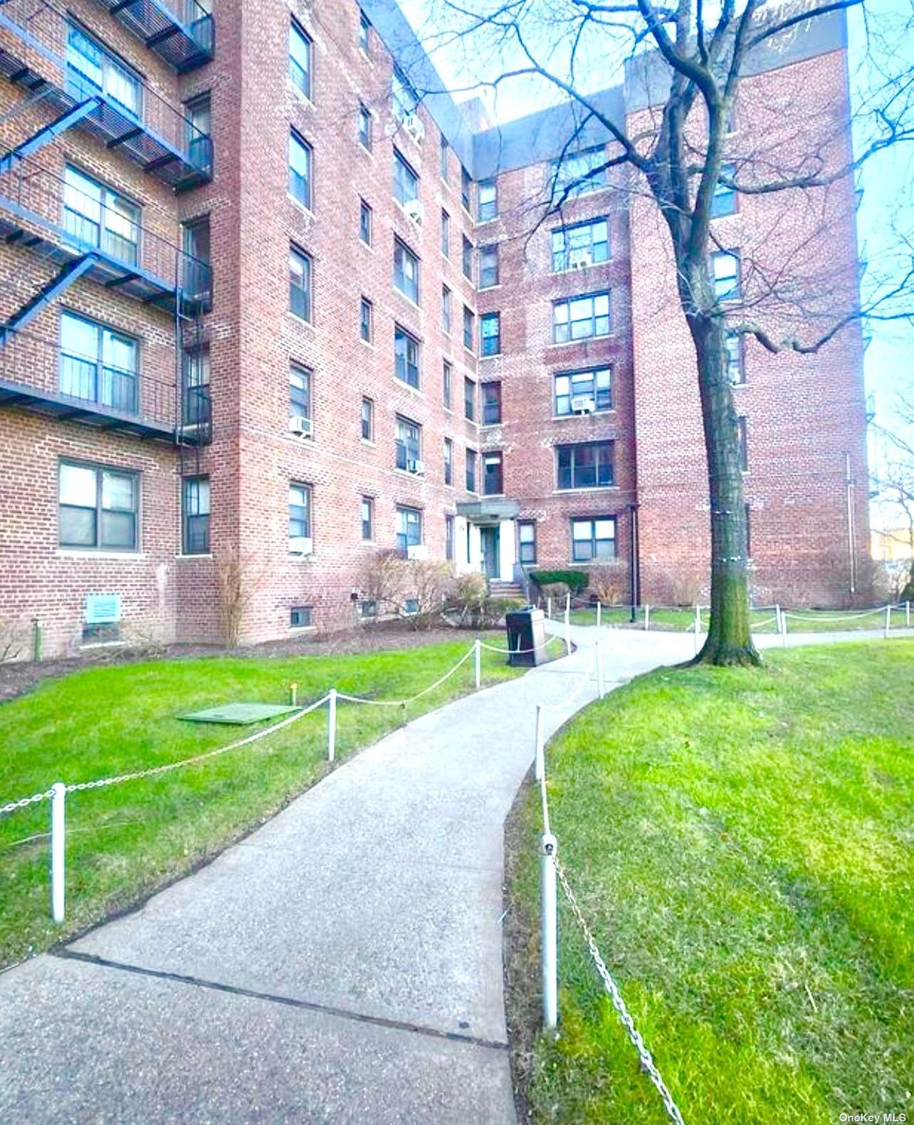 a view of a big building with a big yard and plants