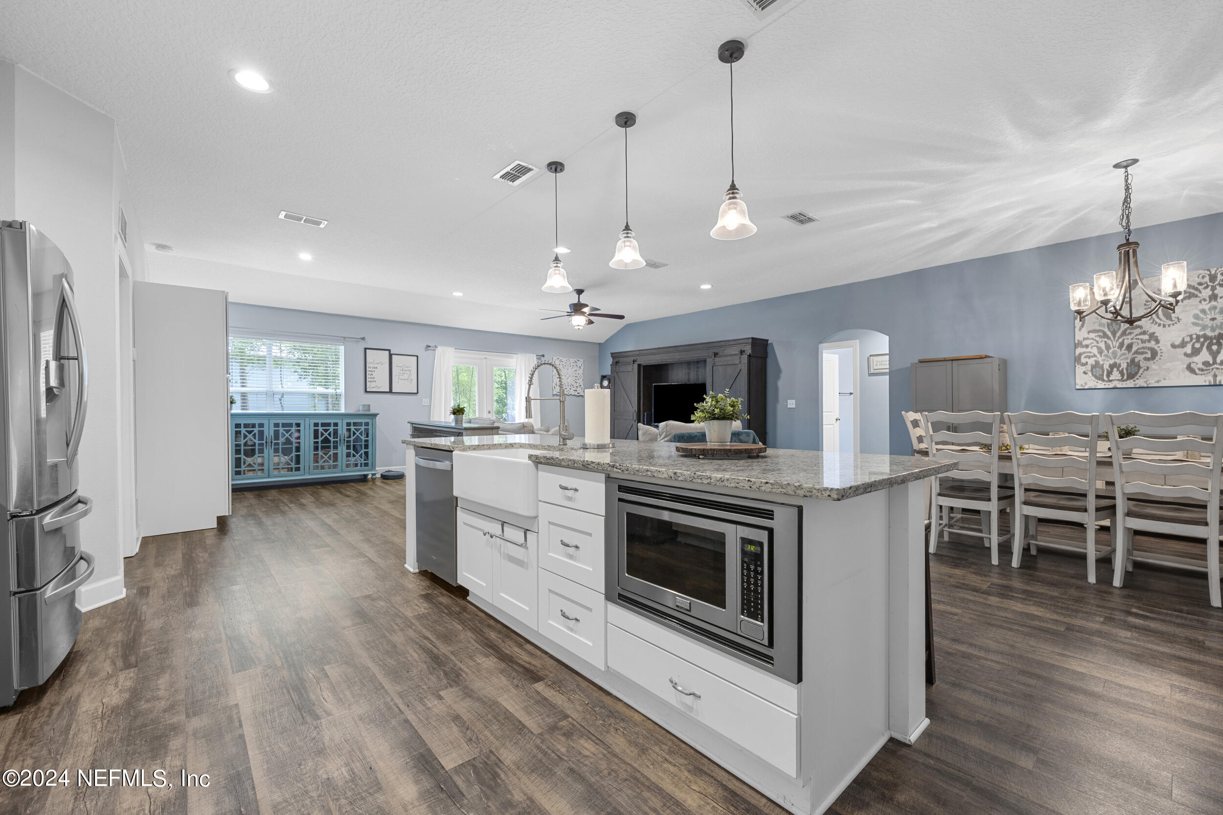 a kitchen with kitchen island granite countertop a sink cabinets and stainless steel appliances