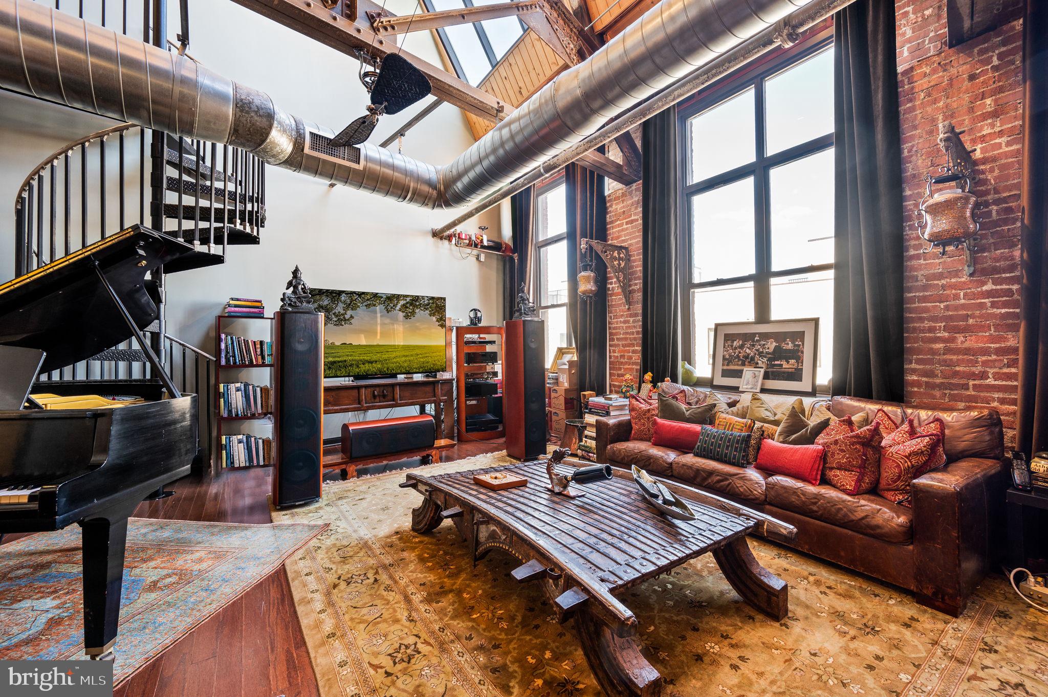 a living room with furniture a flat screen tv and a floor to ceiling window