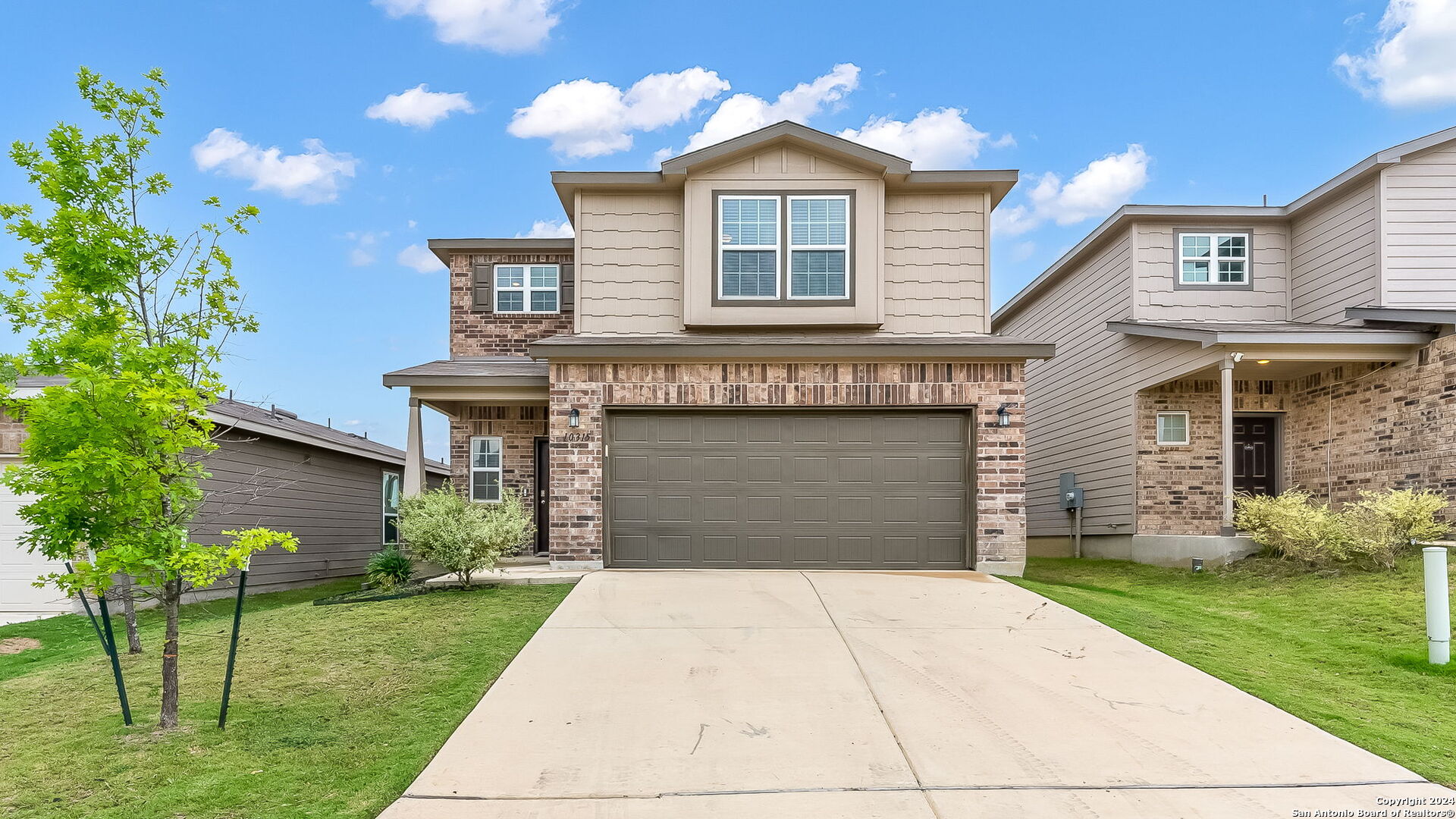 a front view of a house with a yard and garage