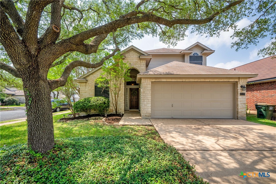 a view of a house with a tree in front of it