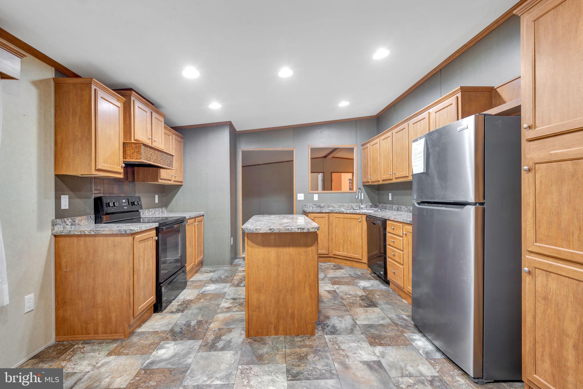 a kitchen with stainless steel appliances granite countertop a refrigerator sink stove microwave and cabinets