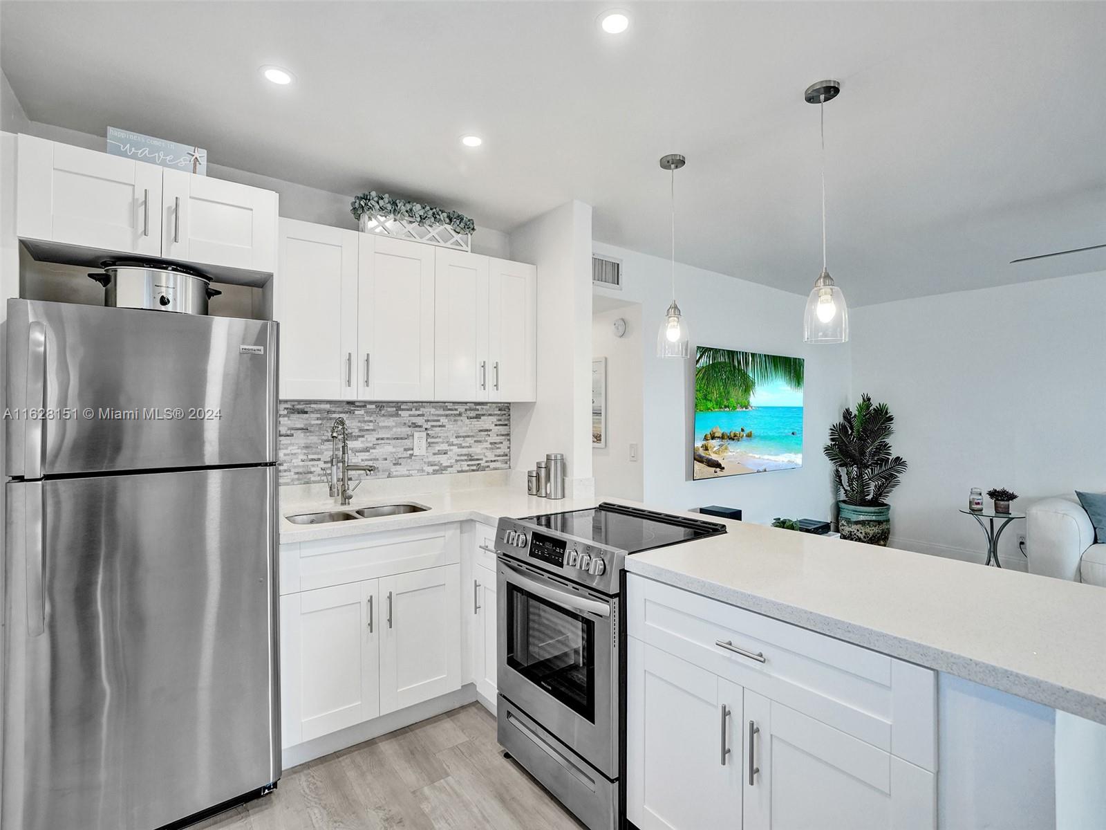 a kitchen with stainless steel appliances a refrigerator sink and cabinets