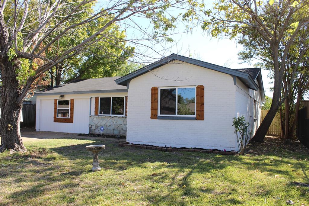 a view of a house with a yard large tree and a fire pit