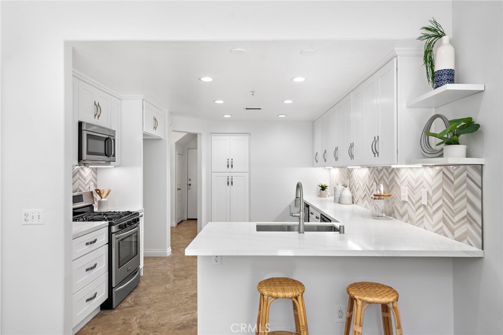 a kitchen with cabinets a sink and chairs