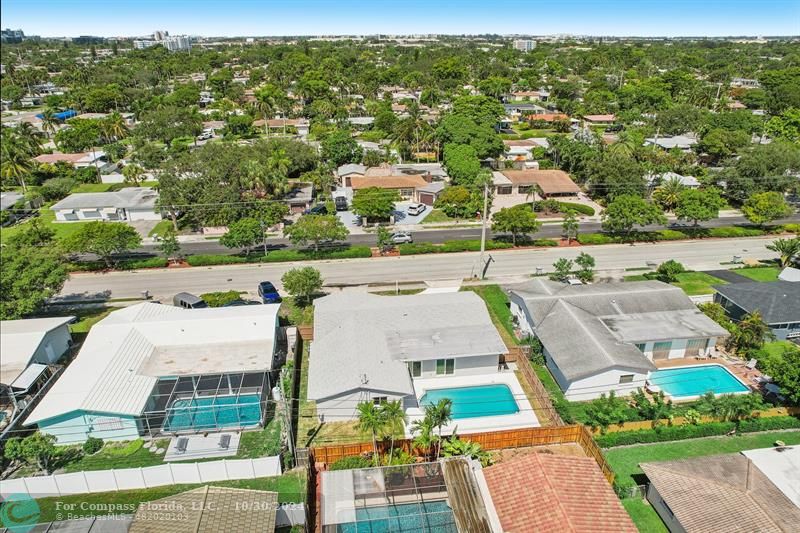 an aerial view of residential houses with outdoor space and parking