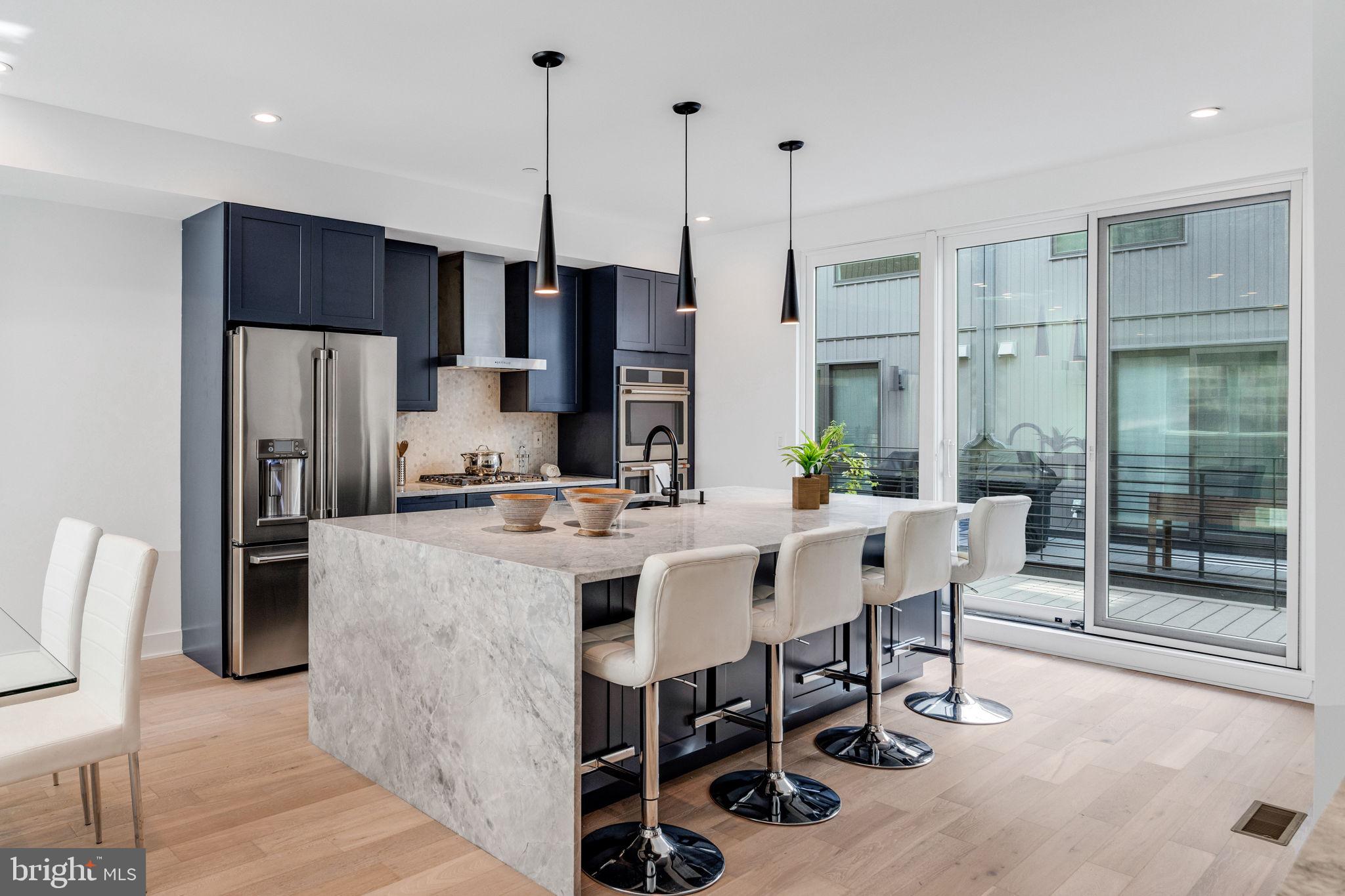 a view of kitchen with refrigerator stove dining table and chairs