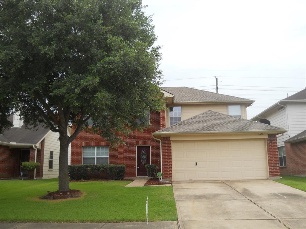 a front view of a house with a garden and trees