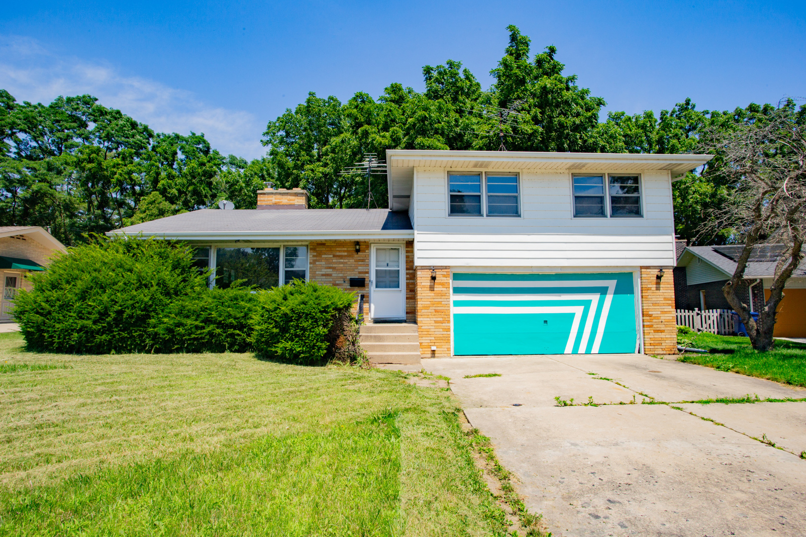 a front view of a house with yard and green space