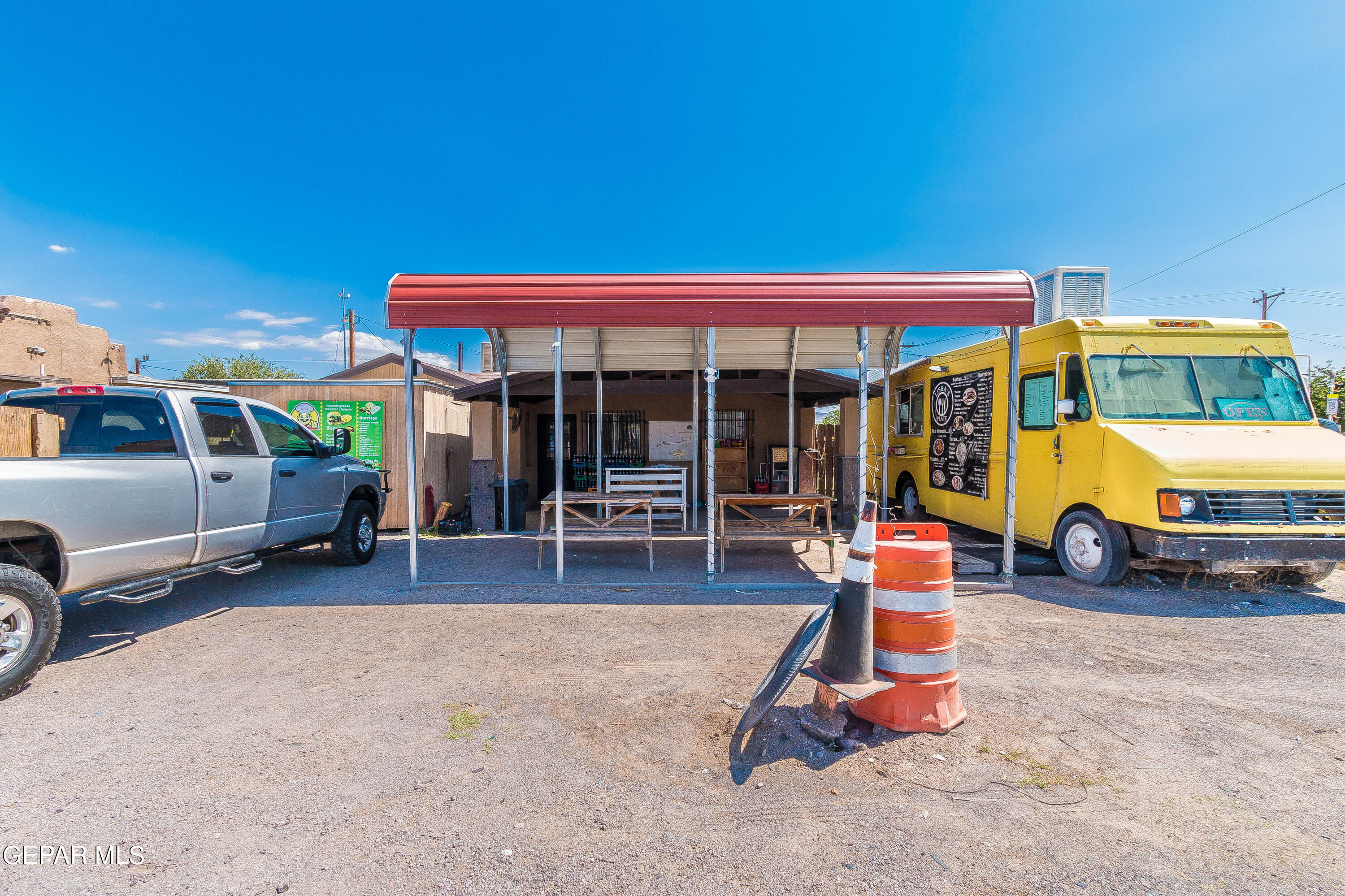 a view of a garage with a table and chairs under an umbrella