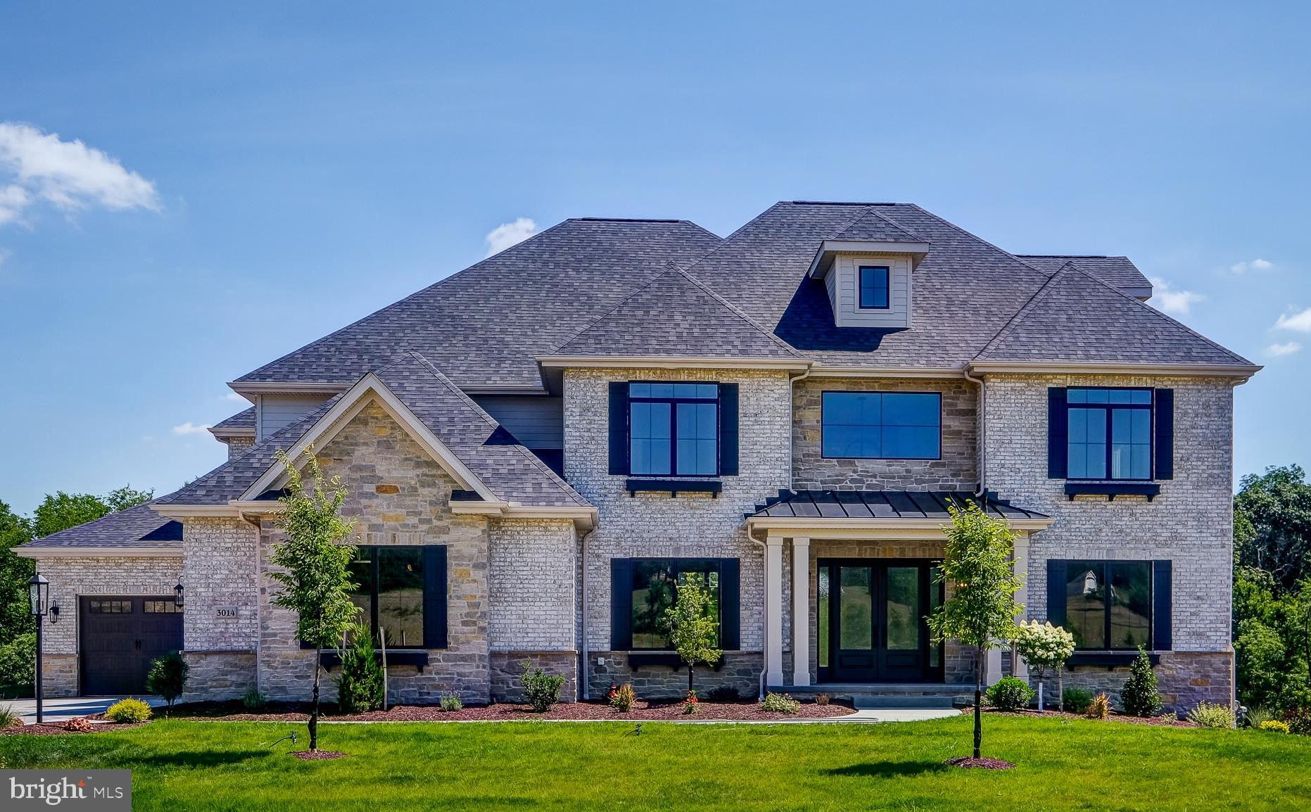 a front view of a brick house with a yard in front of it