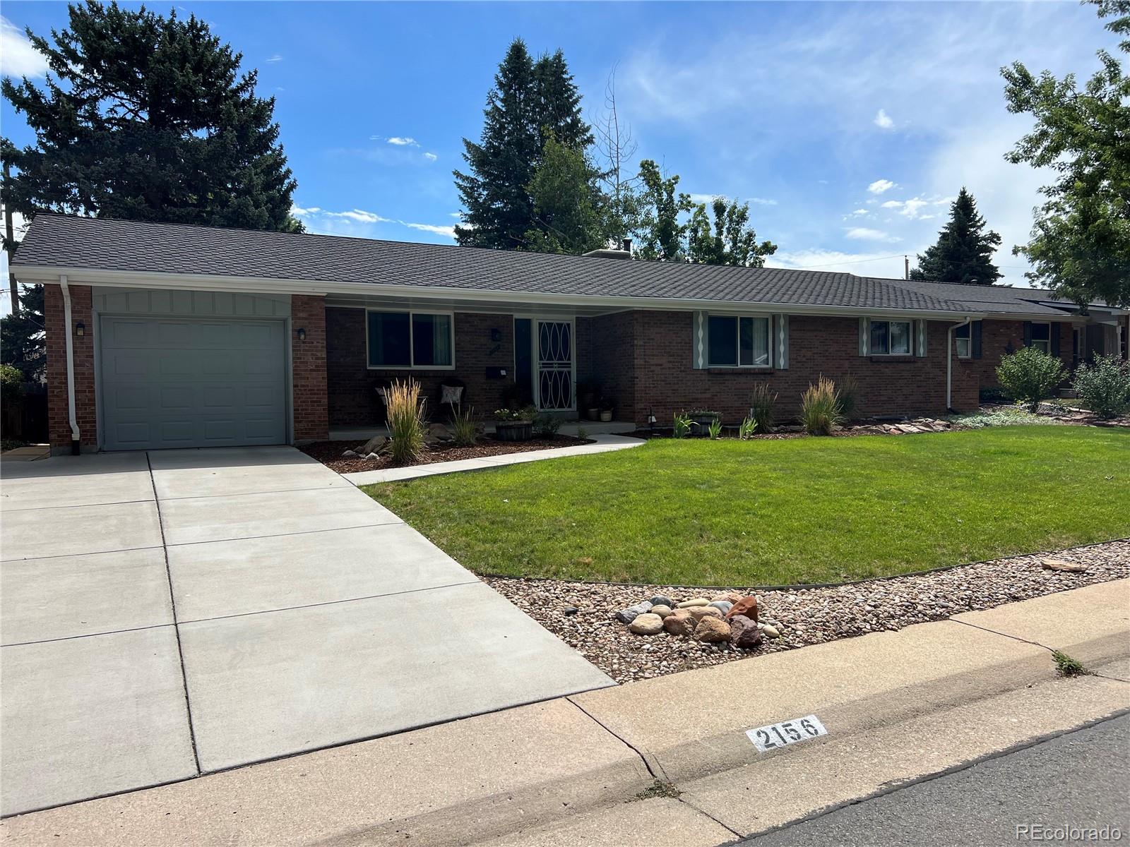 a front view of a house with a yard and trees