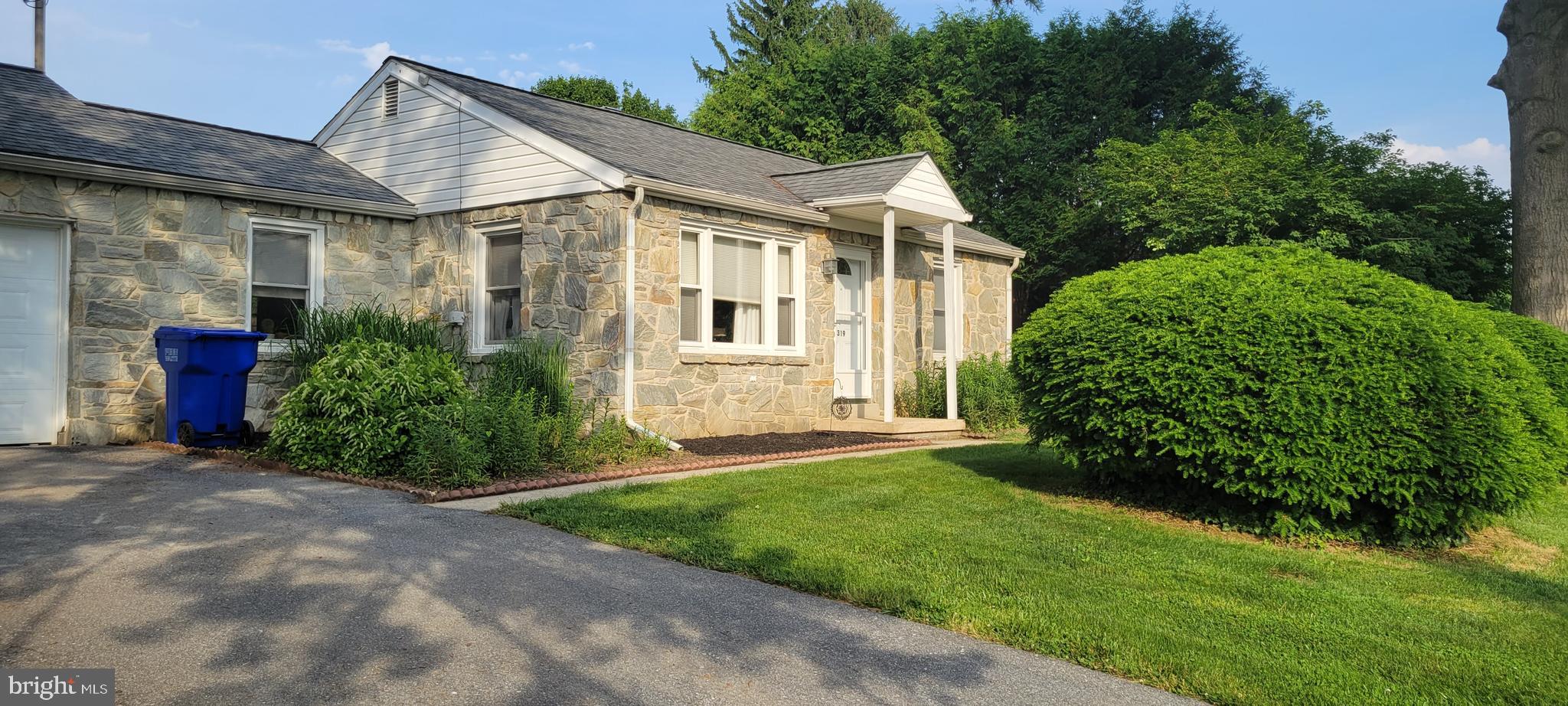 a view of a house with brick walls and a yard with plants