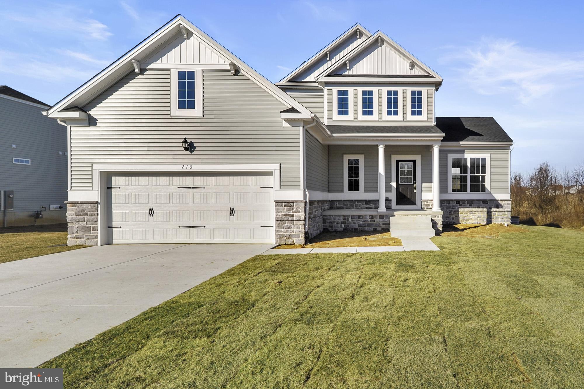 a front view of a house with yard and garage