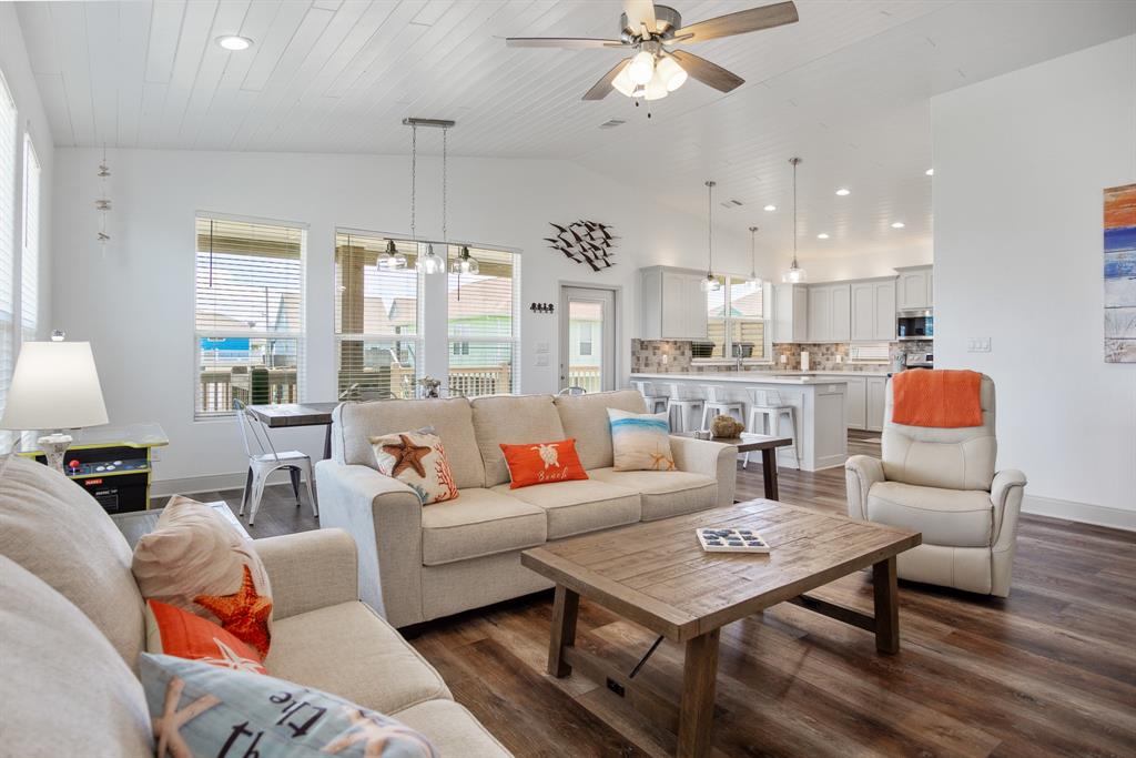 a living room with furniture kitchen view and a chandelier