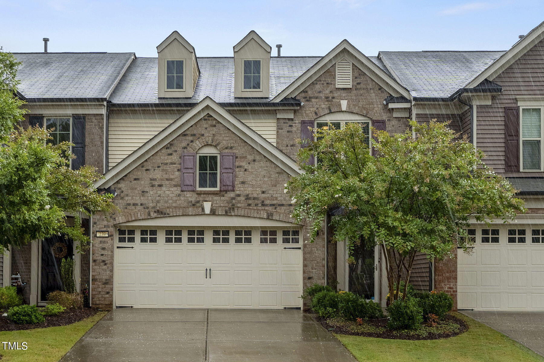 a front view of a house with a yard and trees