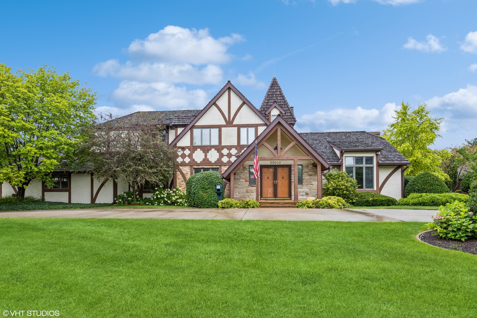 a front view of a house with a yard and trees