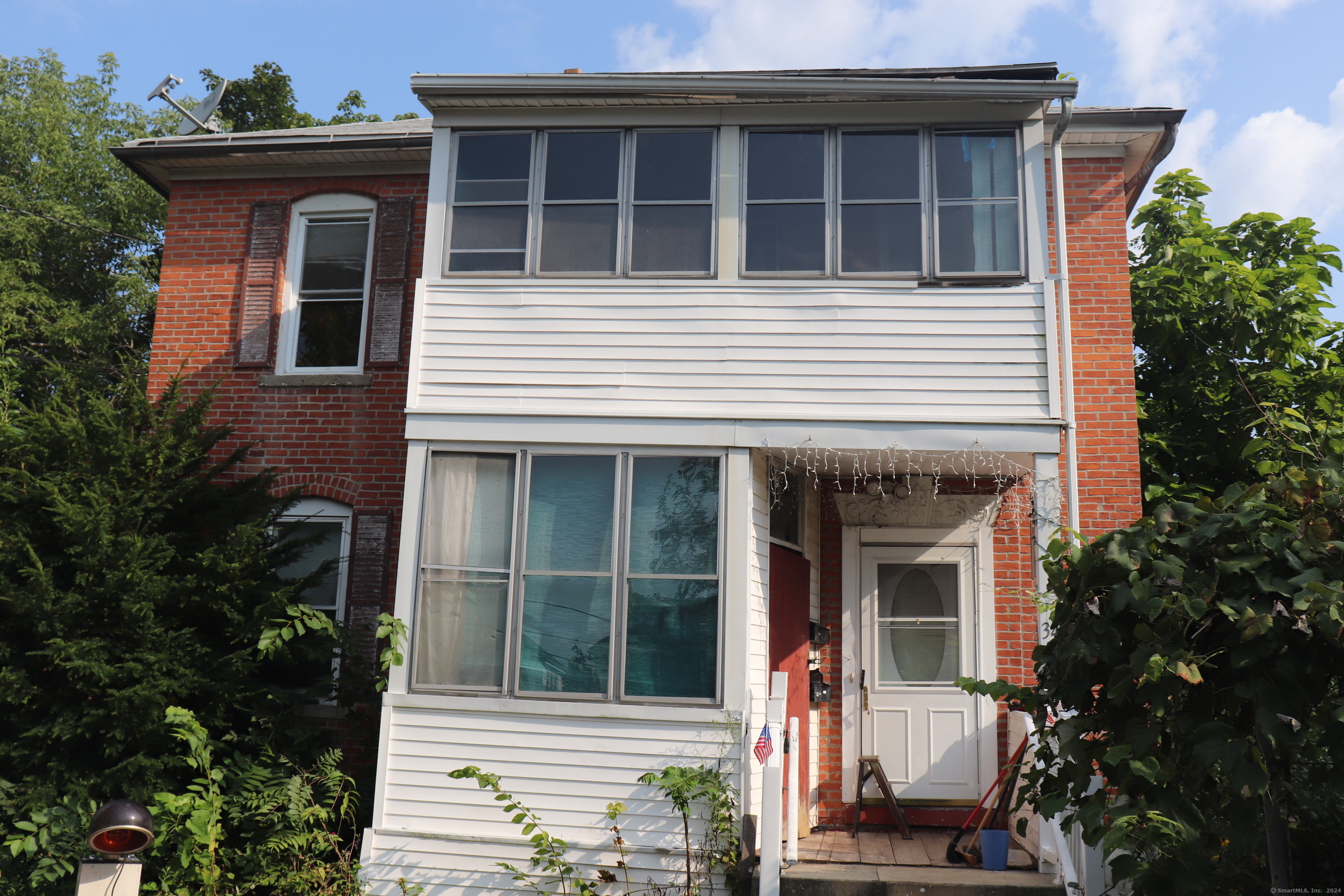 a view of a house with potted plants and a yard