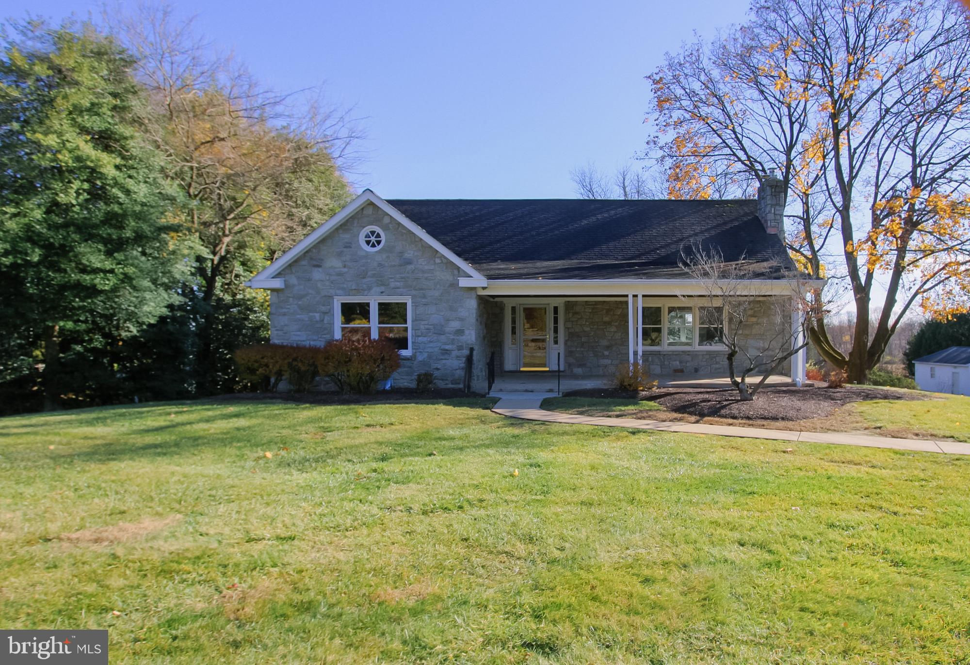 a view of a house with a yard and large tree