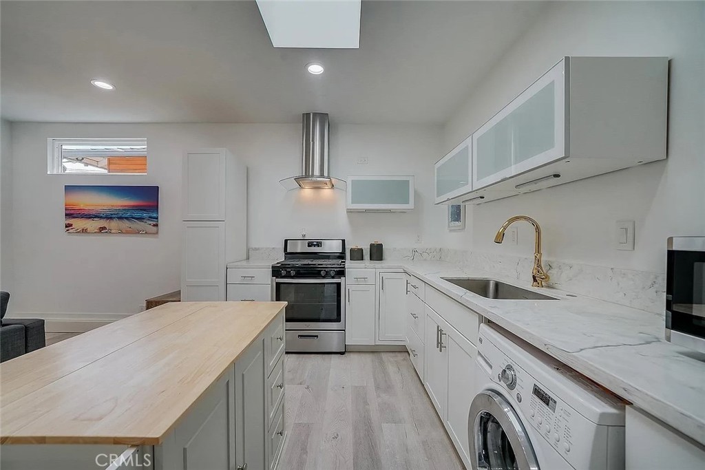 a kitchen with granite countertop a sink a stove and cabinets