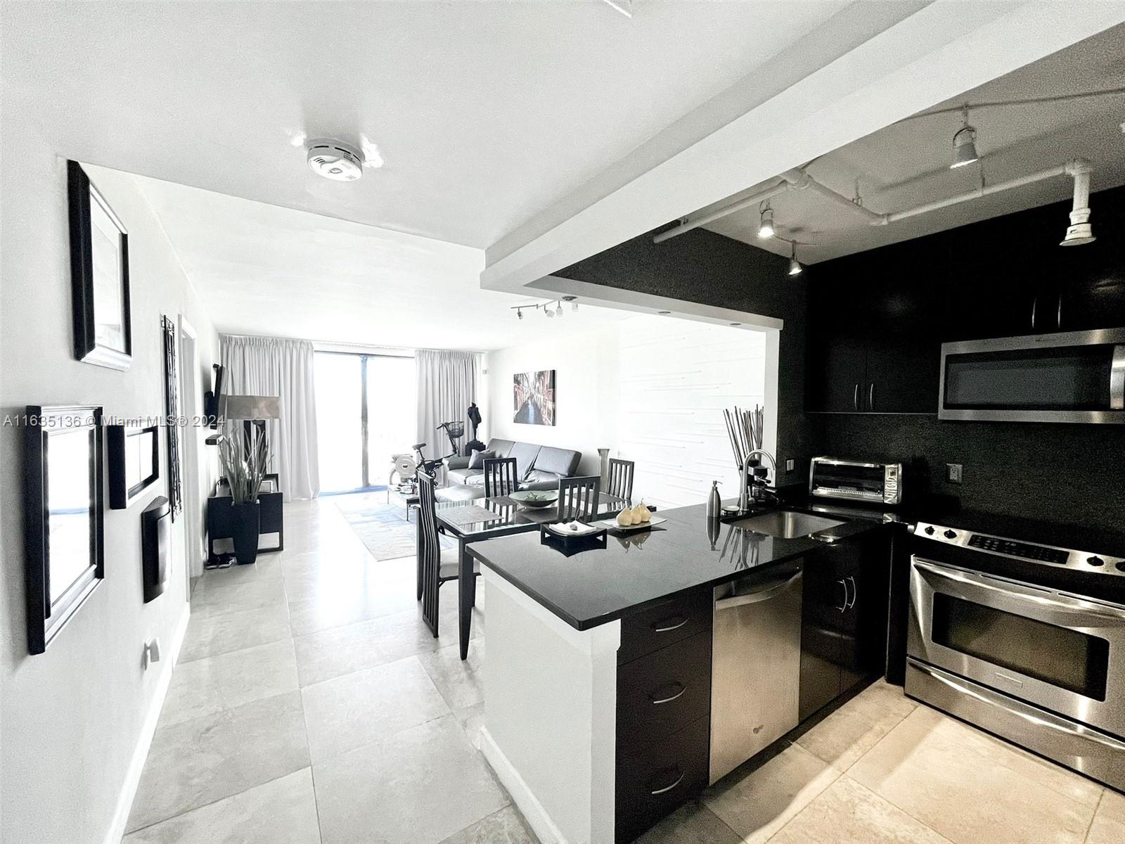 a kitchen that has a lot of cabinets a sink and appliances