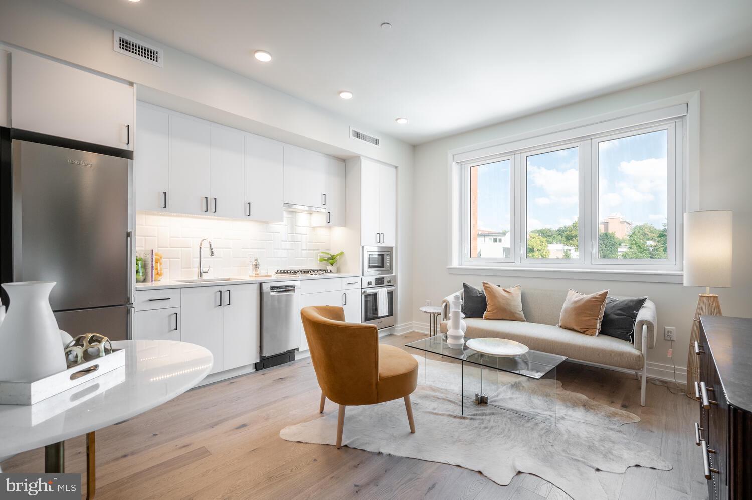 a living room with furniture and a refrigerator