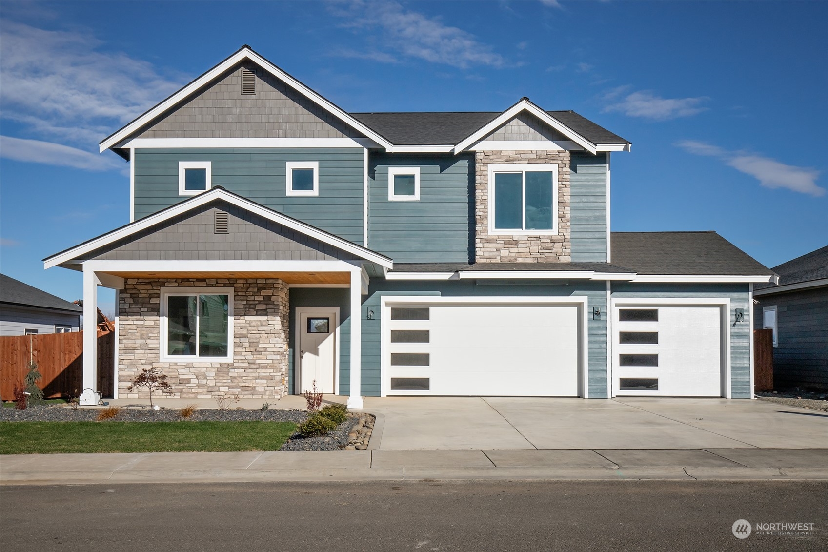 front view of a house with a yard and garage