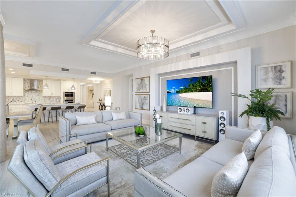 a living room with furniture or chandelier and a wooden floor