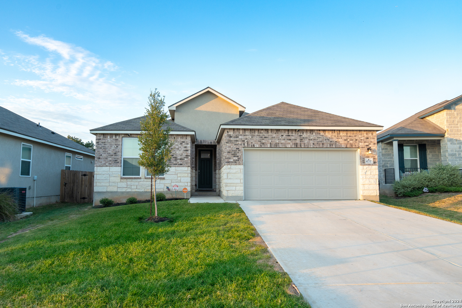 a front view of a house with a yard and garage