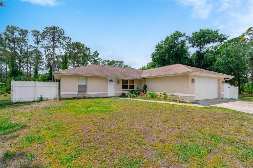 a front view of house with yard and trees in the background