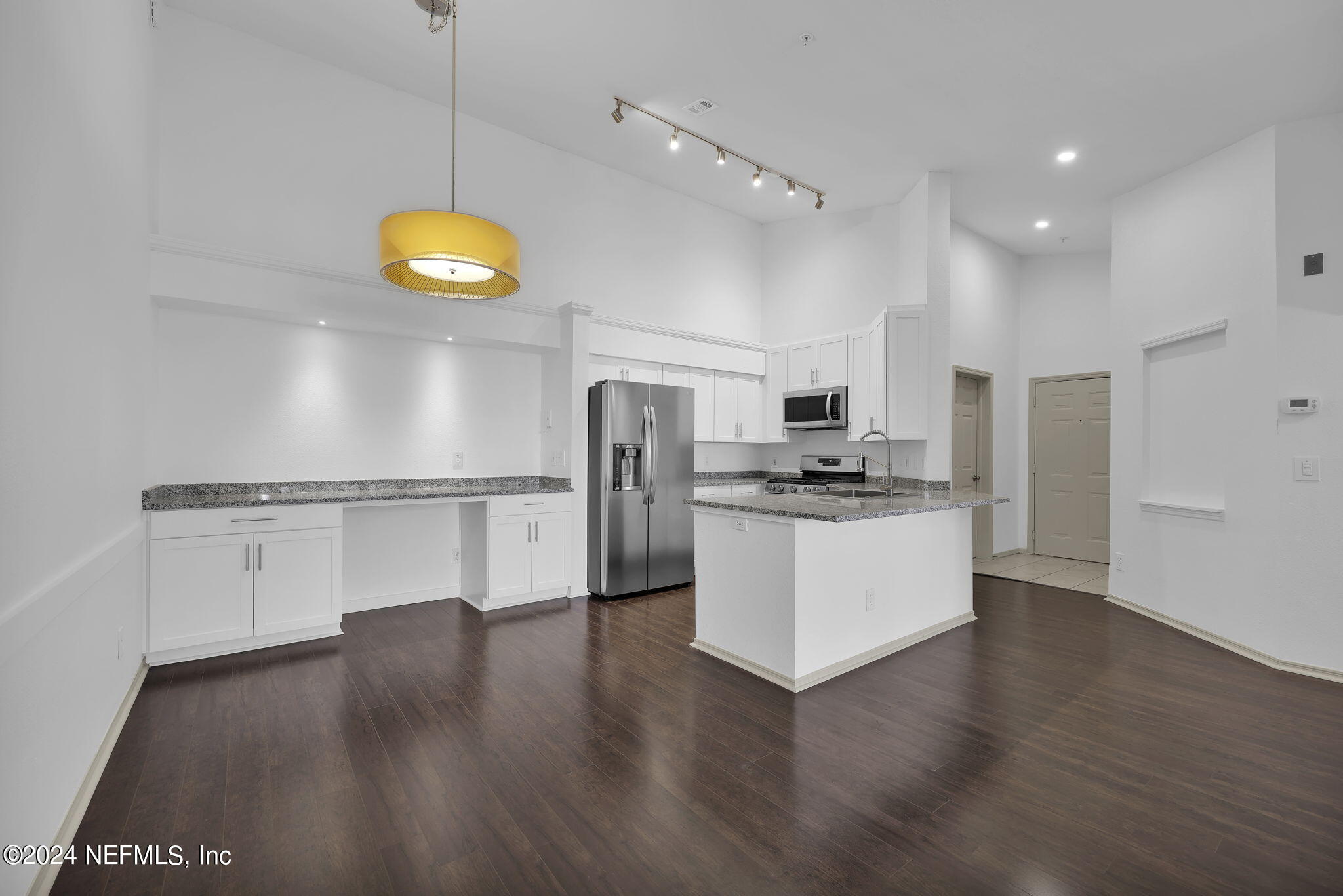 a view of kitchen with stainless steel appliances cabinets and wooden floor