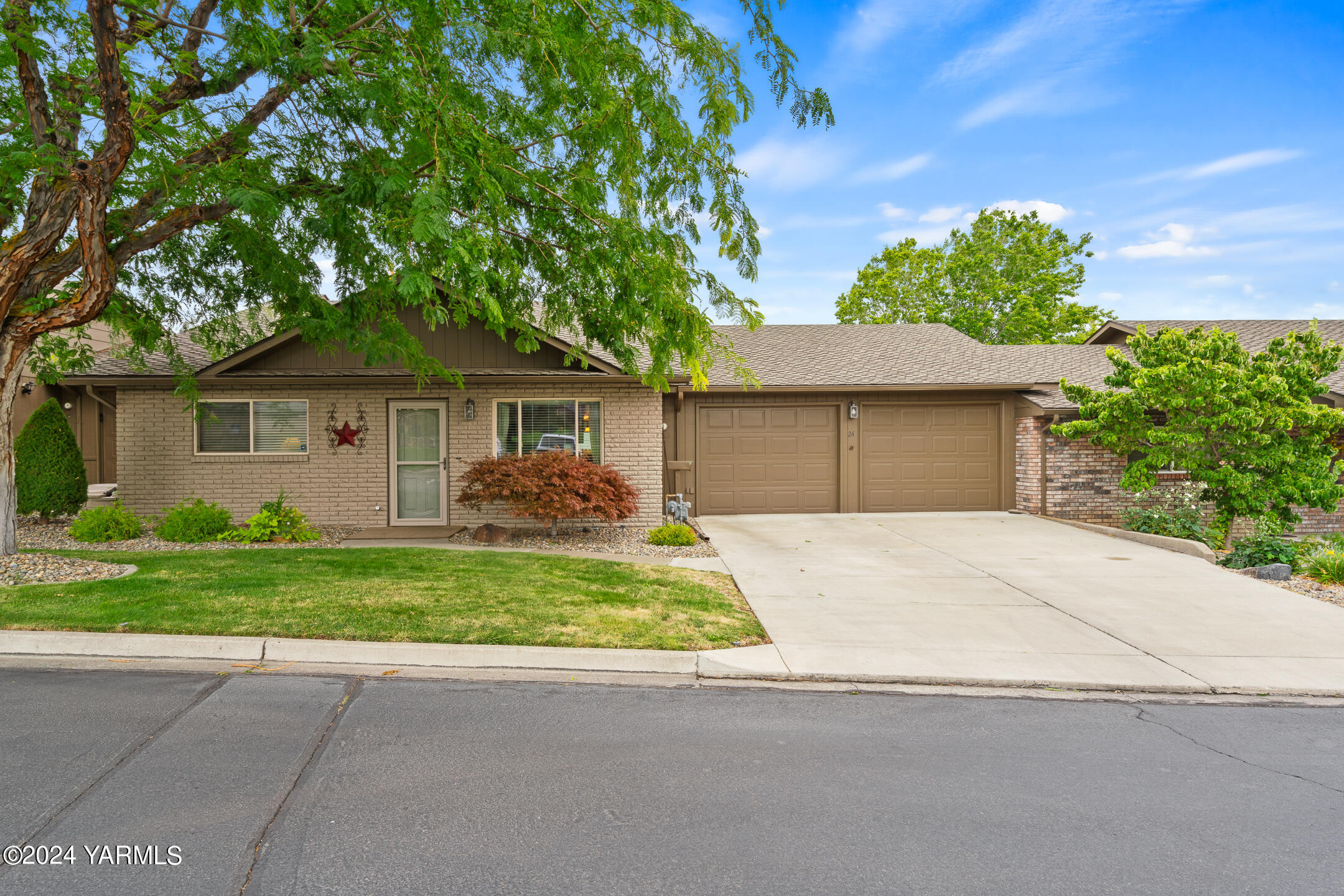 a front view of a house with a yard and a garage