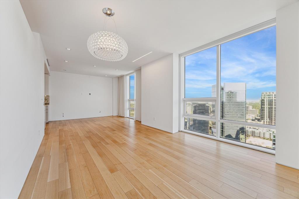 This gallery-inspired, lock-and-leave condo has been completely remodeled and is perched up on the 37th floor of the East Tower with incredible panoramas of downtown and the Galleria. The open dining and family rooms pictured above feature Graf Bros 5” plank rift-cut white oak flooring, Lutron-controlled recessed and wall-washing LED lighting, and a statement chandelier. Floor-to-ceiling windows with Lutron-controlled electronic shades & recessed ceiling-mounted sheer curtains overlook the downtown skyline.