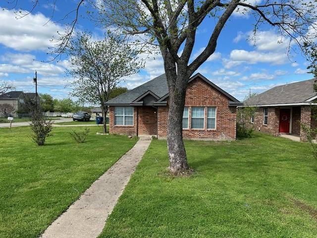 a view of a yard in front of a house with a large tree