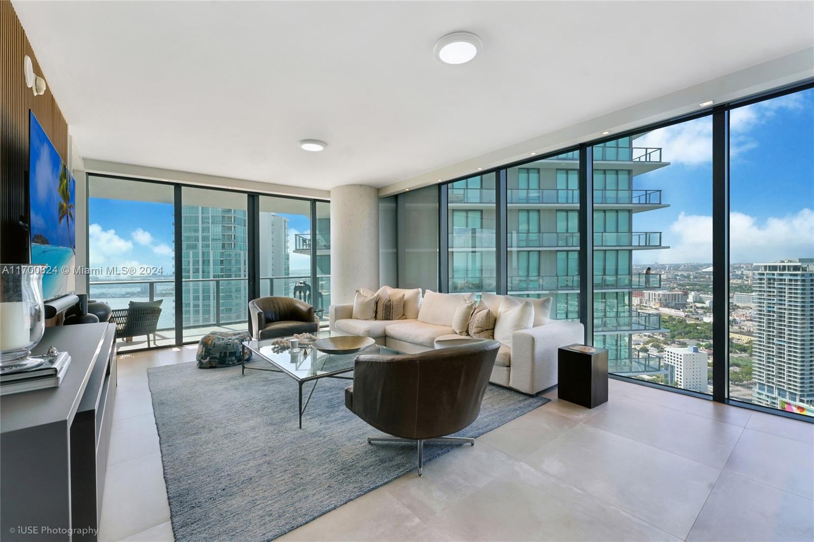 a living room with furniture and a floor to ceiling window