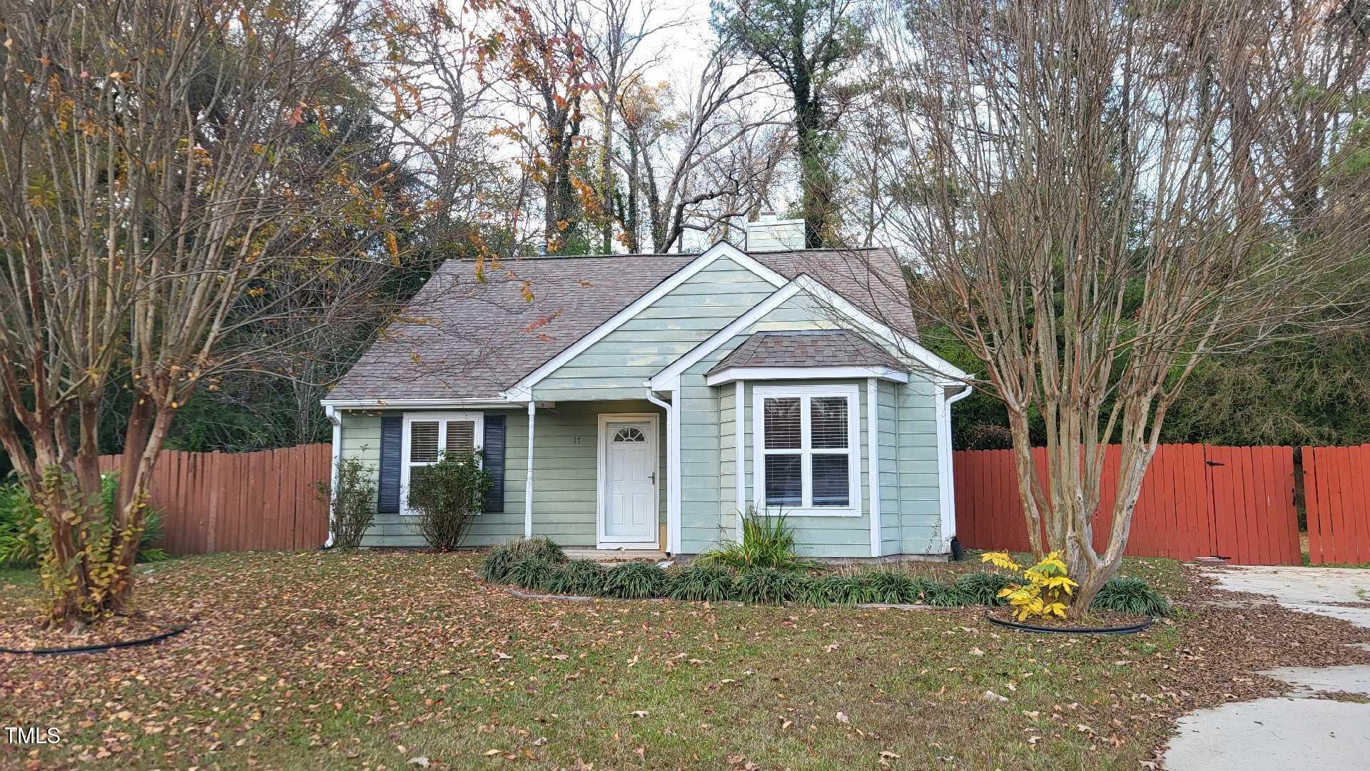 a view of a yard in front of a house with large trees