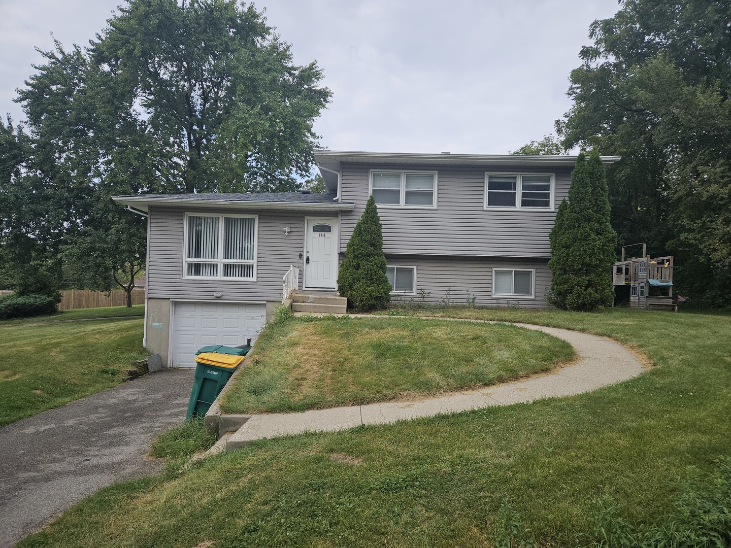 a view of a house with a yard patio and a tree