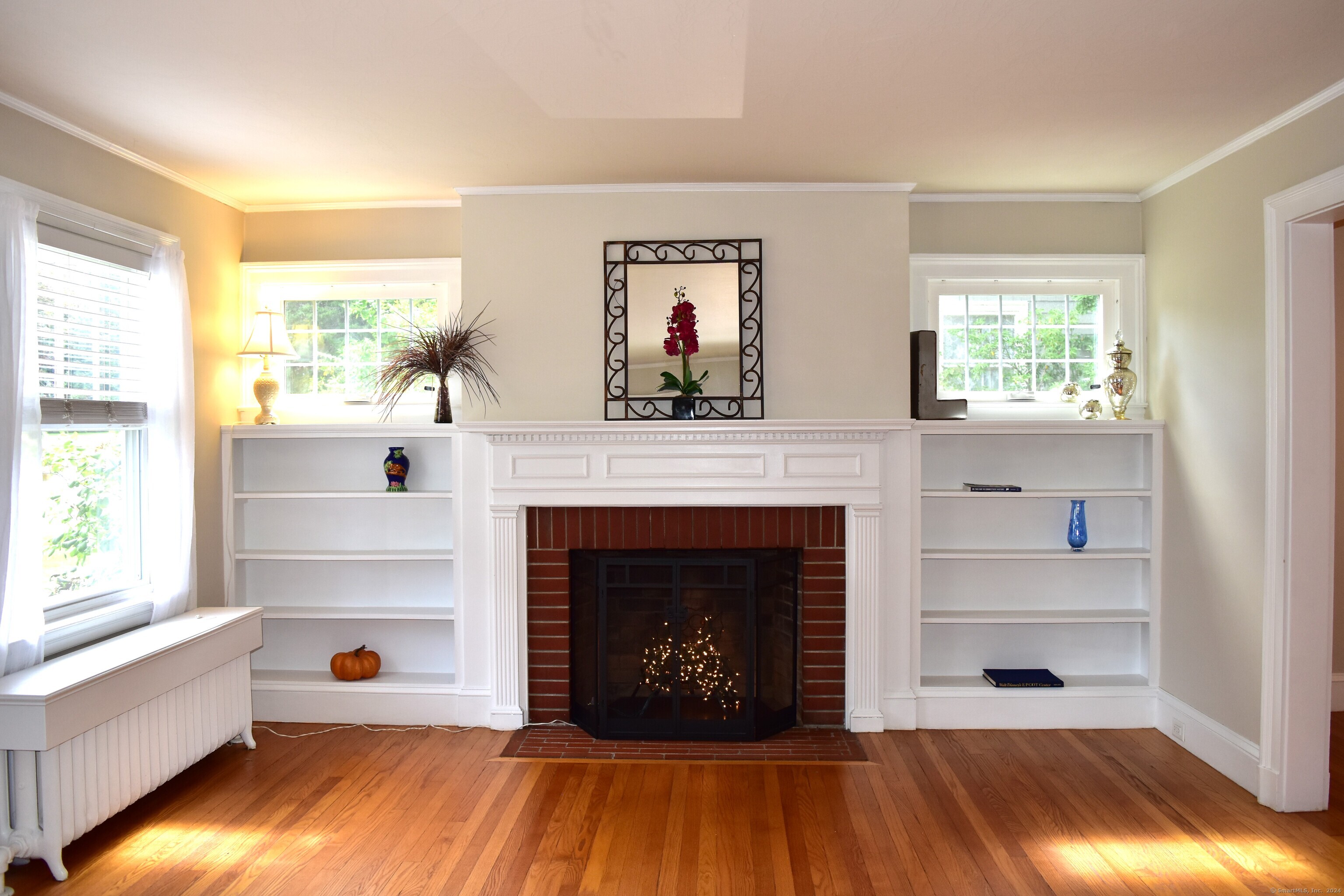 a living room with fireplace and a wooden floor