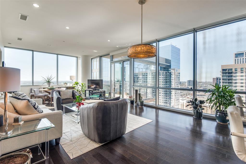 a living room with furniture a large window and wooden floor