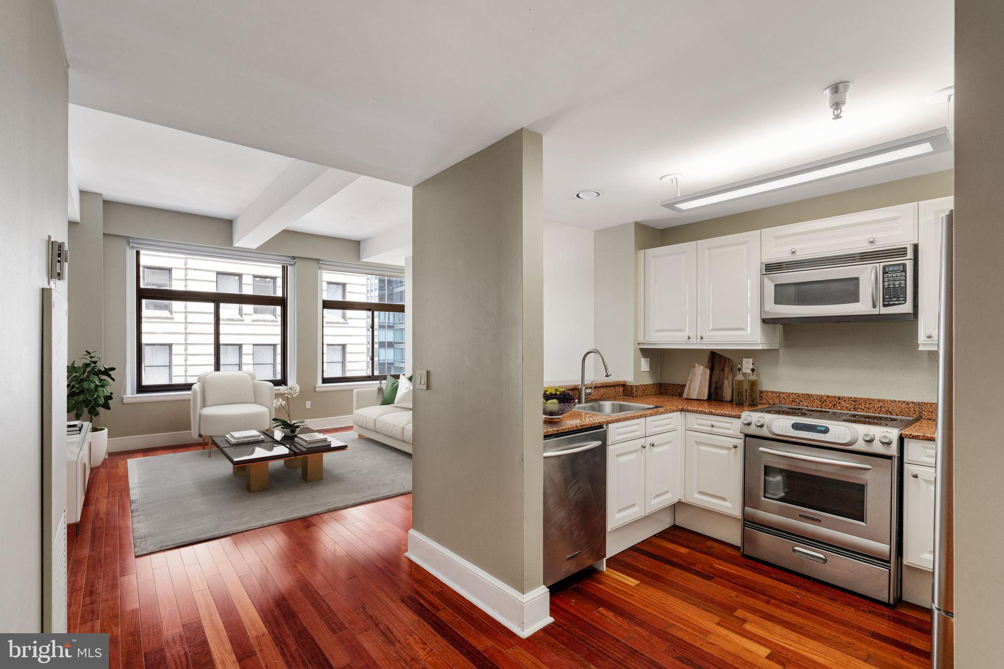 a kitchen with a stove a sink and wooden floor